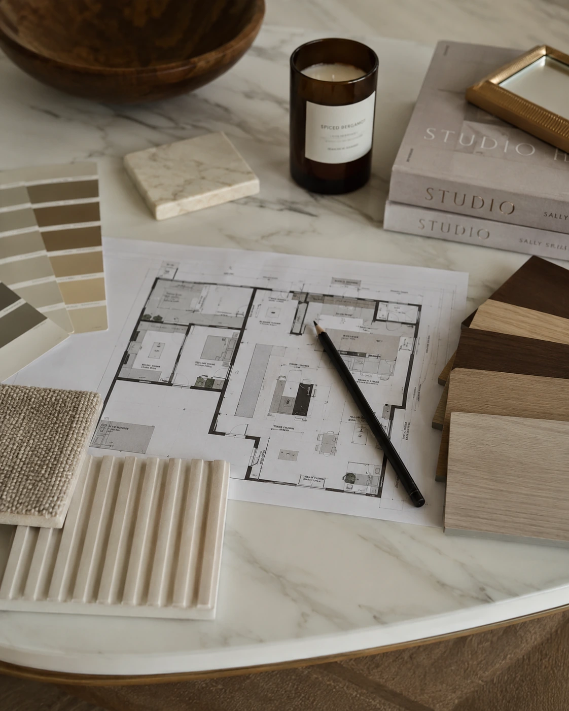 Renovation brief and budget materials with stone, brass, fabric, and notes